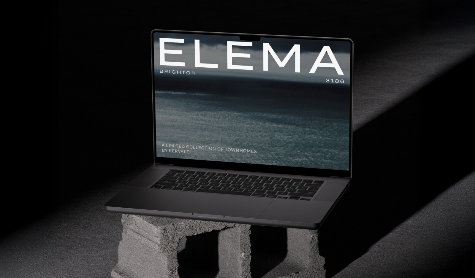 A dark laptop resting on a concrete block displays a website for Elema Brighton 3186, showcasing a personalised property marketing campaign adapting in real-time for the townhouse collection by Kervale.