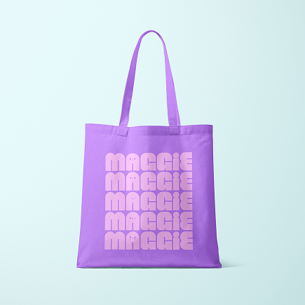 A purple tote bag featuring the name MAGGIE in a repeating pink block font, part of a personalised property marketing campaign.