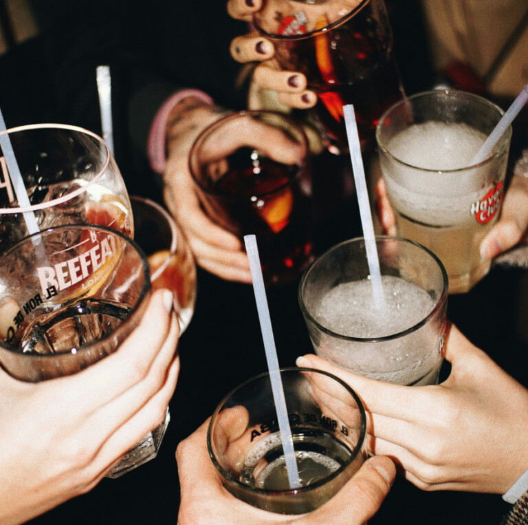 A group of people holding cocktails in a toast for a personalised property marketing campaign.