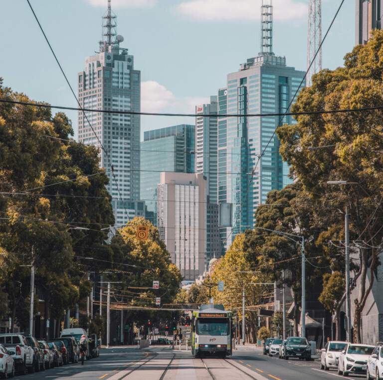 A tram travelling down a city street lined with trees and skyscrapers, capturing the essence of a personalised property marketing campaign adapting in real-time.