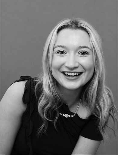 Portrait of a smiling young woman with long hair looking at the camera.
