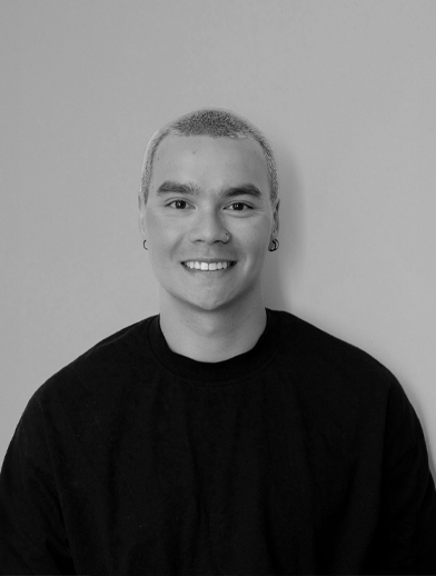 Headshot of a person with a short haircut and small hoop earrings smiling at the camera.